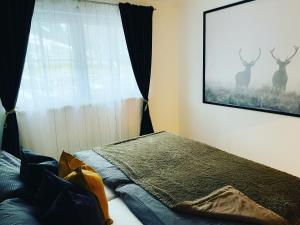 a bedroom with a bed and a window with deer on the wall at Mountainfloor in Grossarl