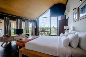 Un dormitorio con una gran cama blanca y una gran ventana. en Gioheven Villa, en Nusa Dua 27 fotos más