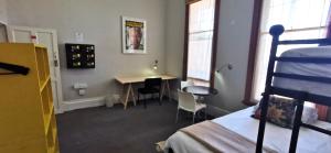 Schlafzimmer mit einem Bett, einem Schreibtisch und einem Tisch in der Unterkunft Ashanti Lodge Backpackers in Kapstadt