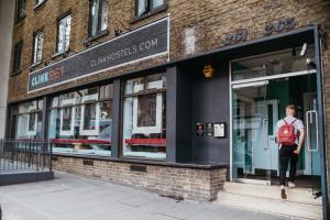 un homme avec un sac à dos debout à l'entrée d'un magasin dans l'établissement Clink261 Hostel, à Londres