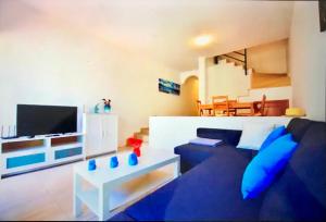 sala de estar con sofá azul y TV en Blue Ocean, en Lajita