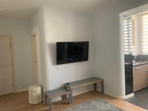 ein Wohnzimmer mit einem Tisch und einem TV an der Wand in der Unterkunft Квартира в новобудові в районі автовокзал , поруч ТРЦ Арена in Riwne