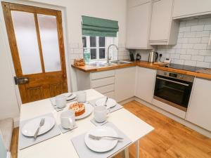 una cocina con una mesa con platos y utensilios. en Court Cottage, en Ripon