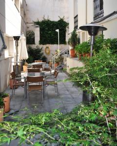 a patio with a table and chairs and plants at Hotel España in Guadalajara