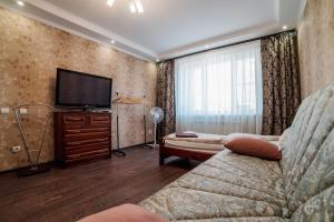 a living room with a couch and a flat screen tv at Apartments Office Wings in Cheboksary