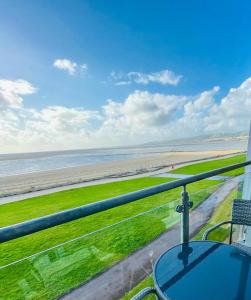 a view of the beach from the balcony of a beach house at Sea view apartment at the beach! in Llanelli