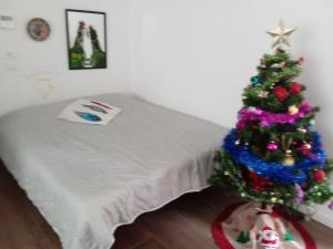 un albero di Natale in una stanza accanto a un letto di white house 1492..il sogno continua.. a Brescia