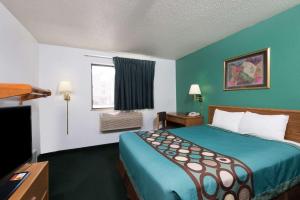a hotel room with a bed and a window at Super 8 by Wyndham New Stanton in New Stanton