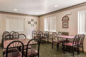 a waiting room with tables and chairs and windows at Super 8 by Wyndham New Stanton in New Stanton