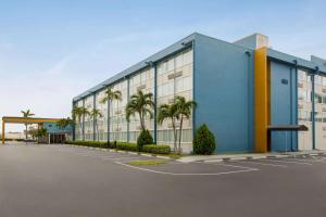 een gebouw met palmbomen op een parkeerplaats bij Days Inn by Wyndham Miami International Airport in Miami
