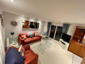 a living room with a couch and a tv at Sea view apartment at the beach! in Llanelli