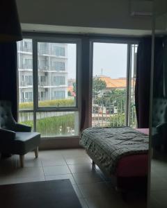 a bedroom with a bed and a large window at Altiz Apartment Bintaro Plaza Residence in Tangerang