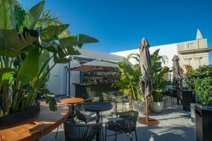 a patio with tables and chairs and plants at Soho Boutique Catedral in Seville