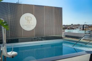une piscine sur le toit d'un bâtiment dans l'établissement Soho Boutique Catedral, à Séville