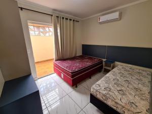 ボンビーニャスにあるMiragem de Bombinhas DUOのベッド2台と窓が備わる小さな客室です。