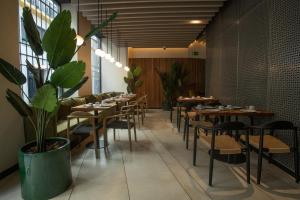a restaurant with wooden tables and chairs and plants at Soho Boutique Catedral in Seville