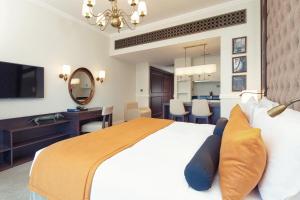 a bedroom with a large bed and a dining room at Dukes The Palm, a Royal Hideaway Hotel in Dubai