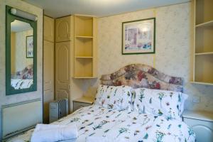 a bedroom with a bed and a mirror at Wind In The Willows: Sleeps 4, Kitchen, bathroom, lounge, WIFI in Napton on the Hill