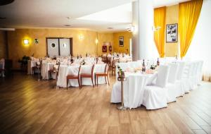 un salón de banquetes con mesas blancas y sillas blancas en Hotel Rivè - Complesso Turistico Campo Smith, en Bardonecchia