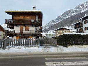 a wooden house with a fence next to a mountain at Chalet dei Reparti Bormio in Bormio
