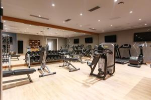 a gym with several treadmills and machines in a room at Ramada by Wyndham Astana in Astana