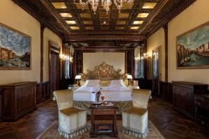 a bedroom with a bed and a table and chairs at Hotel Ai Reali - Small Luxury Hotels of the World in Venice