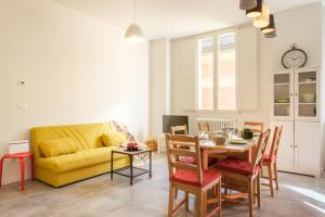 - un salon avec un canapé jaune et une table dans l'établissement Residence del Professore by Studio Vita, à Bologne