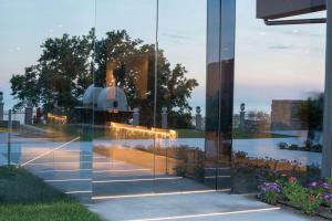 a glass facade of a building with a fountain at Best Western Plus Hotel Terre di Eolo in Patti