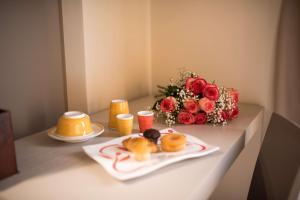 a table topped with plates of food and a vase filled with flowers at Best Western Plus Hotel Terre di Eolo in Patti