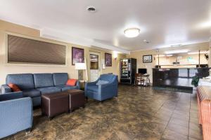 un soggiorno con divano blu e sedie di Quality Inn Airport a Boise