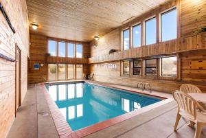a swimming pool in a house with wooden walls and windows at Quality Inn Airport in Boise