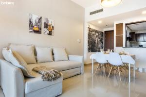 uma sala de estar com um sofá e uma mesa em bnbmehomes - Great Value Spacious Apartment w Moden Furniture - 103 em Dubai
