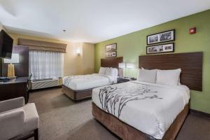 um quarto de hotel com duas camas e uma secretária em Sleep Inn Oxford Anniston I-20 em Oxford