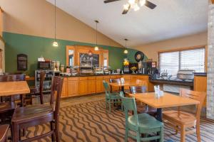 un restaurante con mesas y sillas y una cocina en AmericInn by Wyndham Hartford WI en Hartford