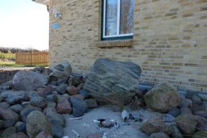 a pile of rocks in front of a brick building at Ferienhaus Kuestenhaus in Pommerby