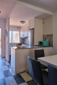 uma cozinha com armários brancos e uma mesa e cadeiras em Casa Marisa Sancti Petri em Novo Sancti Petri