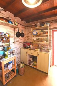 a kitchen with a counter and a sink in a room at Traditional stone house 1bedroom, sea view, Syros in Ano Syros