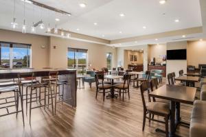 a restaurant with tables and chairs in a room at Sleep Inn & Suites Park City-Wichita North in Park City