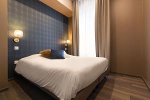 a bedroom with a bed with a teddy bear on it at Legend Majestic - Parking Privé- Climatisation - Gare - Centre Ville in Mâcon