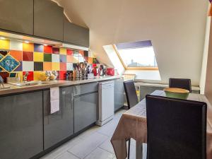 a kitchen with a table and a sink and a counter at Cosy'Appart - LE GERVAIS in Rouen +8 photos