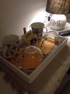 a tray with two cups and a tea kettle on a desk at City Garden Guest House in Olbia