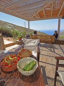a table with a bowl of vegetables on a table at Traditional stone house 1bedroom, sea view, Syros in Ano Syros