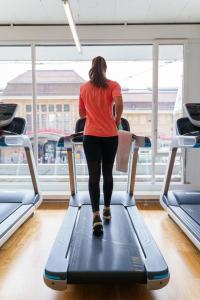 a woman walking on a treadmill in a gym at Continental Hotel Lausanne in Lausanne