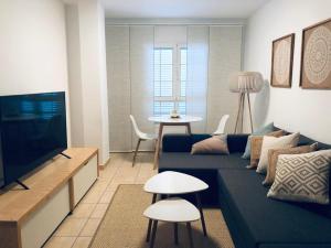 sala de estar con sofá azul y TV en Beautiful apartment in Salinetas Beach, en Salinetas