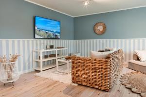 a living room with a couch and a tv on a wall at Luxus Ferienwohnung Beach Style, traumhafter Seeblick in Fulda