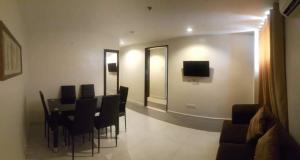 a dining room with a table and chairs and a television at Annex Hotel Tavern in Surigao