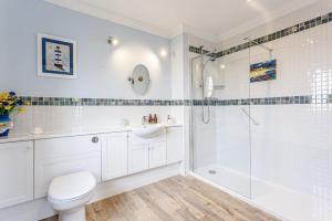 a bathroom with a shower and a toilet and a sink at Glenerrick House - Loch Ness country manor - hot tub and sauna in Whitebridge +18 photos