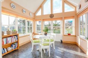 a dining room with a table and chairs and windows at Glenerrick House - Loch Ness country manor - hot tub and sauna in Whitebridge