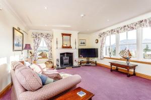 a living room with a couch and a fireplace at Glenerrick House - Loch Ness country manor - hot tub and sauna in Whitebridge