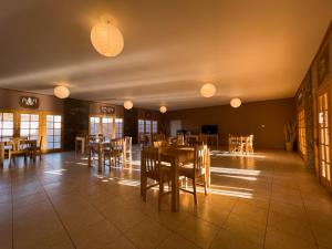 un comedor con mesas, sillas y luces en Ittai Hotel, en San Pedro de Atacama